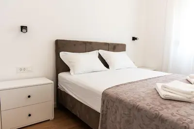 a bedroom with a bed with white sheets and white pillows at Konzul apartment in Kotor