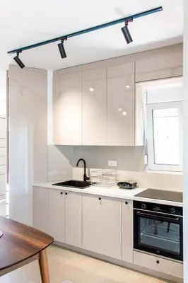 a kitchen with white cabinets and a sink and a table at Konzul apartment in Kotor