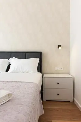 a bedroom with a bed and a night stand at Konzul apartment in Kotor
