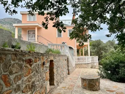 a large pink house behind a stone wall at Villa Sky Mountain in Bar