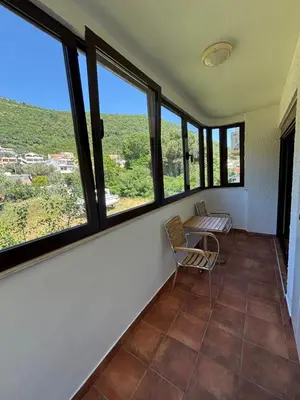 a room with a table and chairs and windows at GO COAST Petrovac in Petrovac na Moru