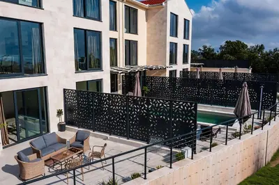a balcony of a building with chairs and a swimming pool at Orange Tree Pool Villas - Sea View and Private Pool in Reževići