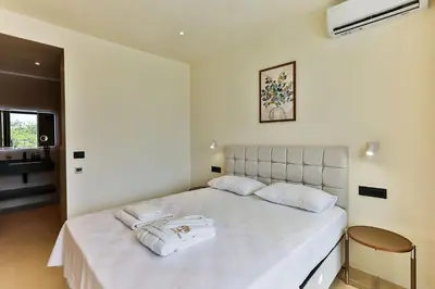 a bedroom with a white bed with two towels on it at Orange Tree Pool Villas - Sea View and Private Pool in Reževići