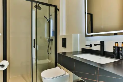 a bathroom with a toilet and a sink and a shower at Orange Tree Pool Villas - Sea View and Private Pool in Reževići