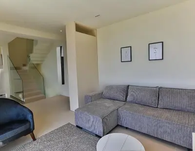a living room with a couch and a chair at Orange Tree Pool Villas - Sea View and Private Pool in Reževići