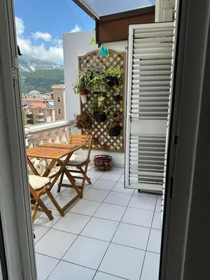a balcony with a table and a wooden table at Apartman Mimi in Budva