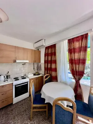 a kitchen with a table and chairs and a kitchen with a sink at Casa Loza in Sveti Stefan