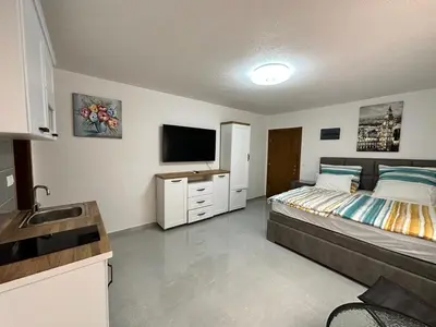 a bedroom with a bed and a flat screen tv at Апартаменты - студия in Bar