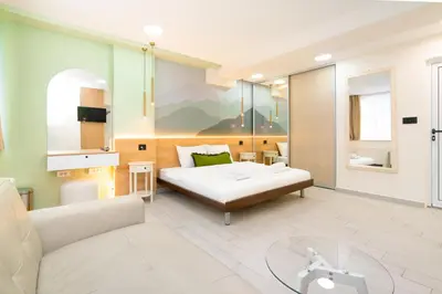 a living room with a bed and a table at 7 Hills Rooms in Podgorica