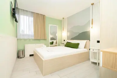 a bedroom with a large white bed in a room at 7 Hills Rooms in Podgorica
