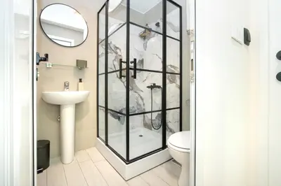 a bathroom with a shower with a toilet and a sink at 7 Hills Rooms in Podgorica
