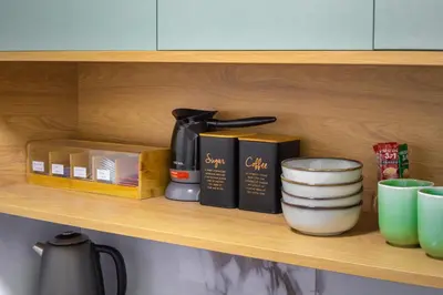 a shelf with a coffee maker and other items on it at 7 Hills Rooms in Podgorica