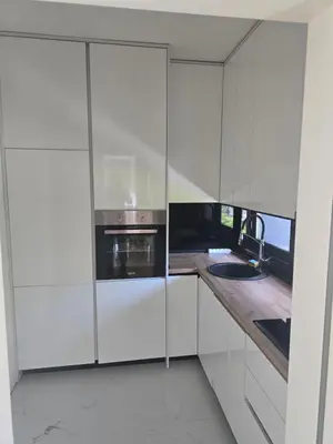 a white kitchen with a stove and a sink at Lux apartment in Podgorica