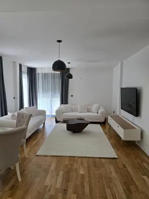 a living room with white furniture and a flat screen tv at Lux apartment in Podgorica
