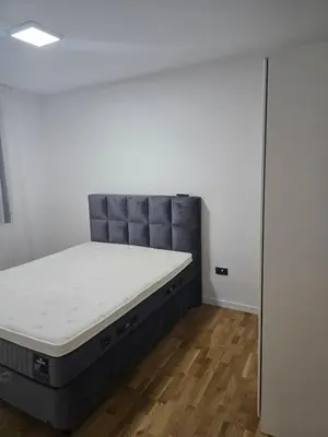 a bedroom with a bed in the corner of a room at Lux apartment in Podgorica