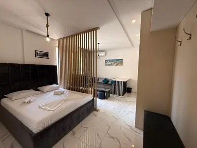 a bedroom with a large bed with a wooden headboard at Aura Tower in Rafailovici