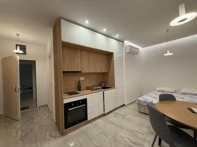 a room with a kitchen and a bed and a table at Aura Tower in Rafailovici