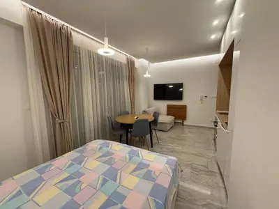 a bedroom with a bed and a table and a tv at Aura Tower in Rafailovici