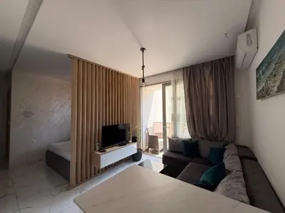a living room with a couch and a tv at Aura Tower in Rafailovici