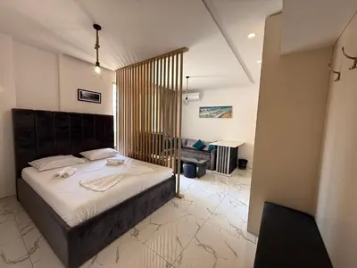 a bedroom with a large bed and a desk at Aura Tower in Rafailovici