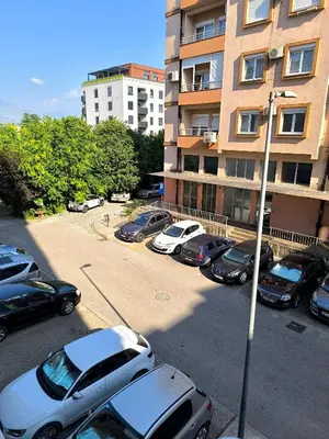 a parking lot with cars parked in front of a building at Apartment 365 in Podgorica