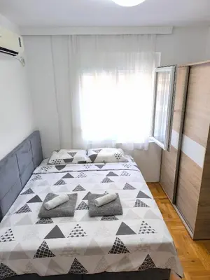 a bedroom with a bed with pillows on it at Apartment 365 in Podgorica