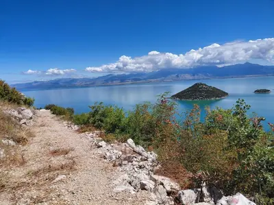 a dirt road next to a large body of water at Eco-Apartment Ostros Skutarisee