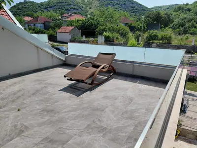a chair sitting on top of a roof at Eco-Apartment Ostros Skutarisee
