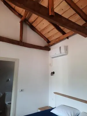 a room with a ceiling with wooden beams at Eco-Apartment Ostros Skutarisee