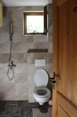 a bathroom with a toilet and a window at Lotos - vikendica 1 in Bar