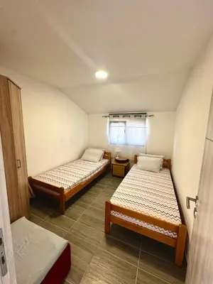 a small room with two beds and a window at Uros Apartments in Tivat
