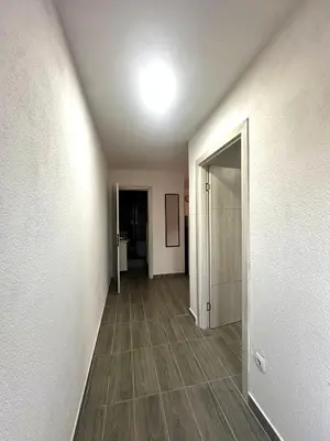 an empty room with a hallway with wood floors and a door at Uros Apartments in Tivat