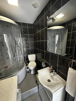 a bathroom with a sink and a toilet and a mirror at Uros Apartments in Tivat