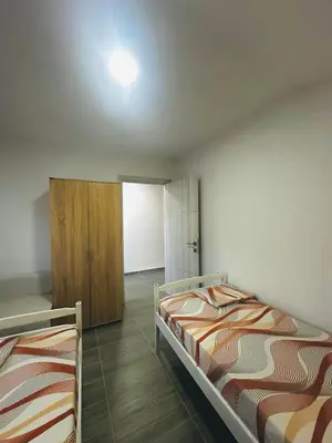 a bedroom with two beds and a cabinet at Uros Apartments in Tivat