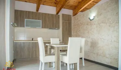 a dining room with a table and white chairs at Lotos - family stan in Bar