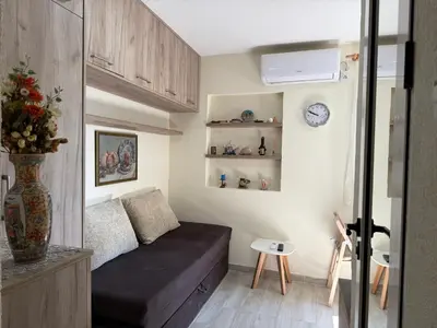 a living room with a couch in a small room at Private double room in the Old Town in Budva