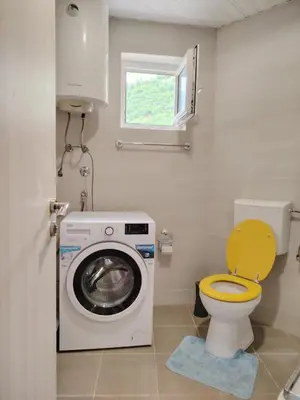 a bathroom with a washing machine and a toilet at Apartments Lučijana in Budva