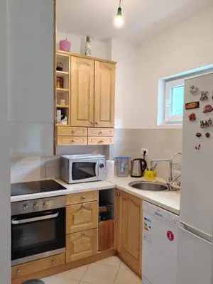 a kitchen with wooden cabinets and a microwave at Apartments Lučijana in Budva