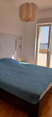 a bedroom with a bed with a blue comforter at Penthouse Becici in Budva