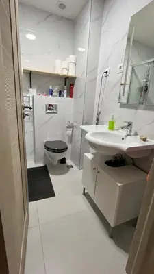 a white bathroom with a sink and a toilet at Penthouse Becici in Budva