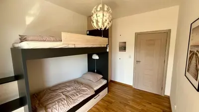 a bedroom with two bunk beds and a chandelier at Penthouse Becici in Budva