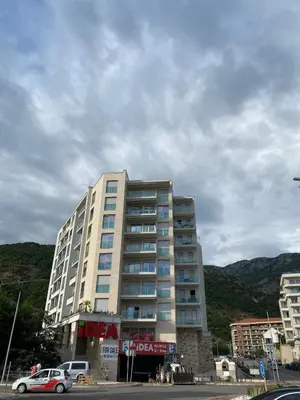 a tall building with a car parked in front of it at Montesin cozy studio in Budva