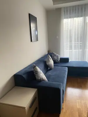 a blue couch in a living room with a window at Montesin cozy studio in Budva