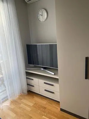 a living room with a tv and a clock on the wall at Montesin cozy studio in Budva