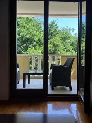 an open door to a balcony with a chair and a table at Sun Apartment in Petrovac na Moru