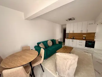 a living room with a green couch and a table at Apartment AB in Bar