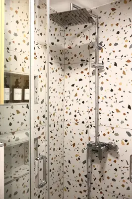 a shower stall in a bathroom with a wall covered in butterflies at Fighen Apartment in Budva