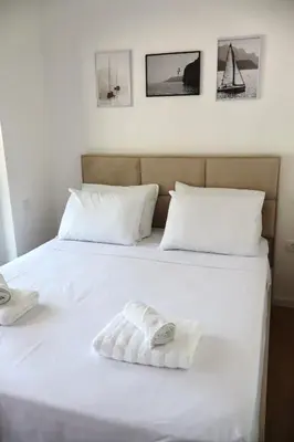 a white bed with two white towels on it at Fighen Apartment in Budva