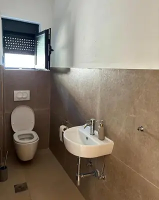 a bathroom with a sink and a toilet at B&K Villa Kruče Rooms in Ulcinj
