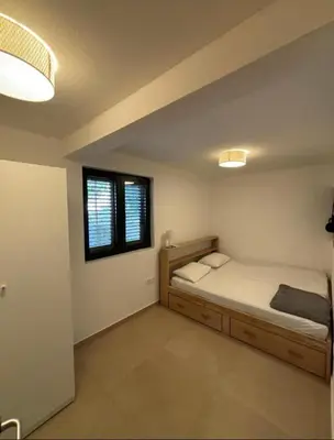 a bedroom with a bed and two windows at B&K Villa Kruče Rooms in Ulcinj
